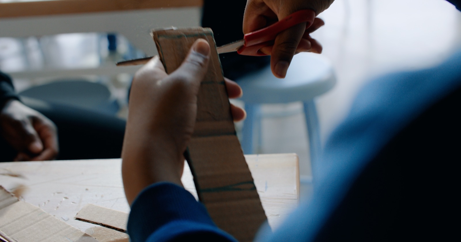 A student uses their hands to assemble a small object