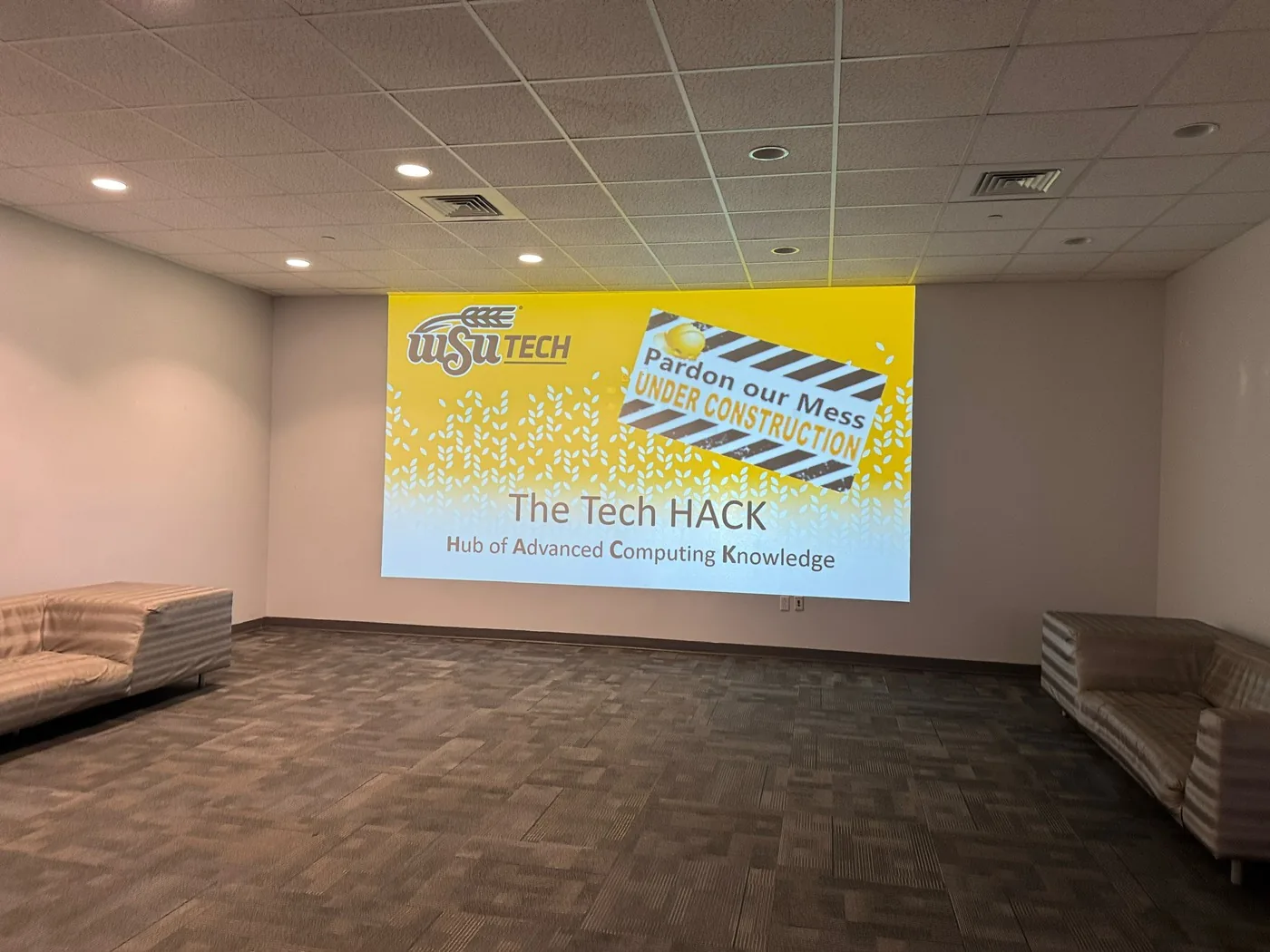 Empty WSU Tech room with a projected slide reading The Tech HACK, Hub of Advanced Computing Knowledge